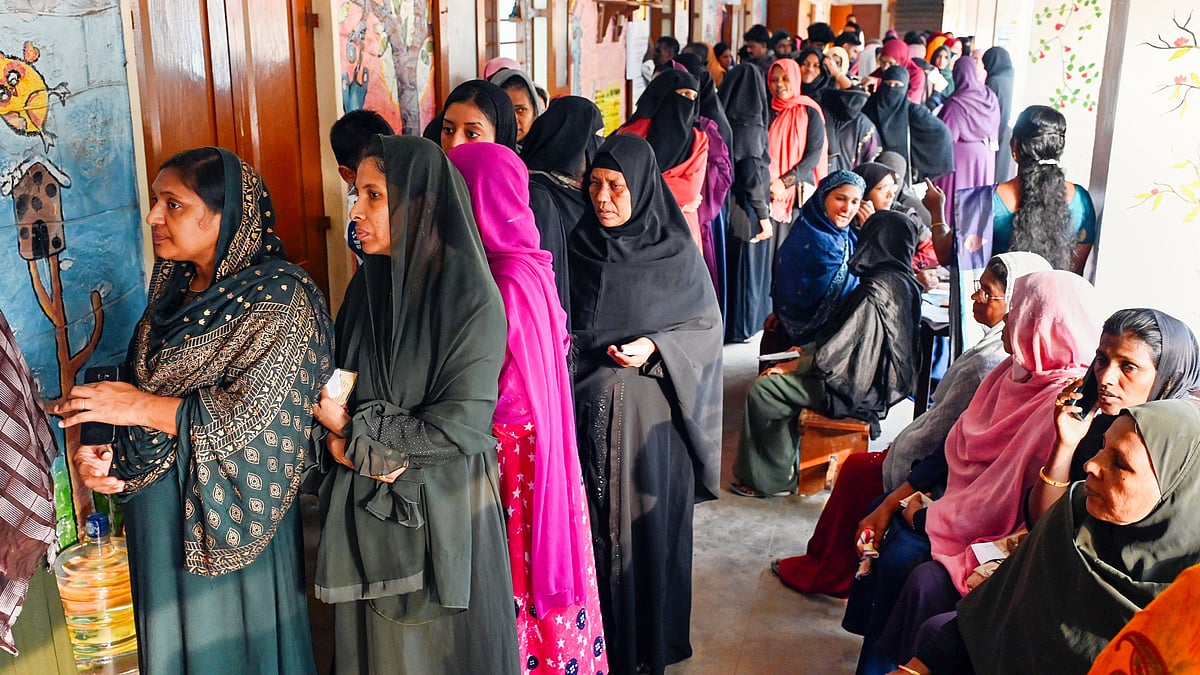 Voters wait at a polling station in Thiruvananthapuram on 26 April (photo: PTI)