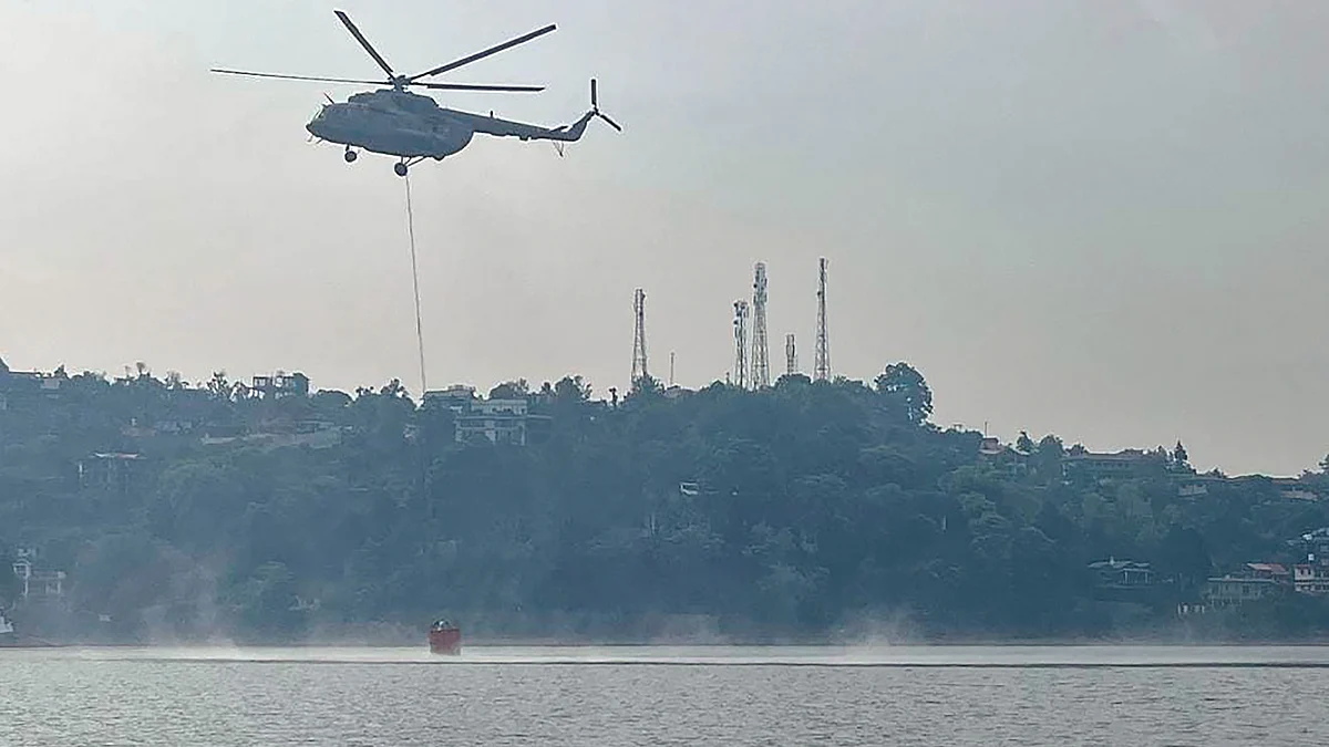 A Mi-17 V5 helicopter conducts 'Bambi Bucket Operation' to control the fire in Nainital on 27 April (photo: PTI)