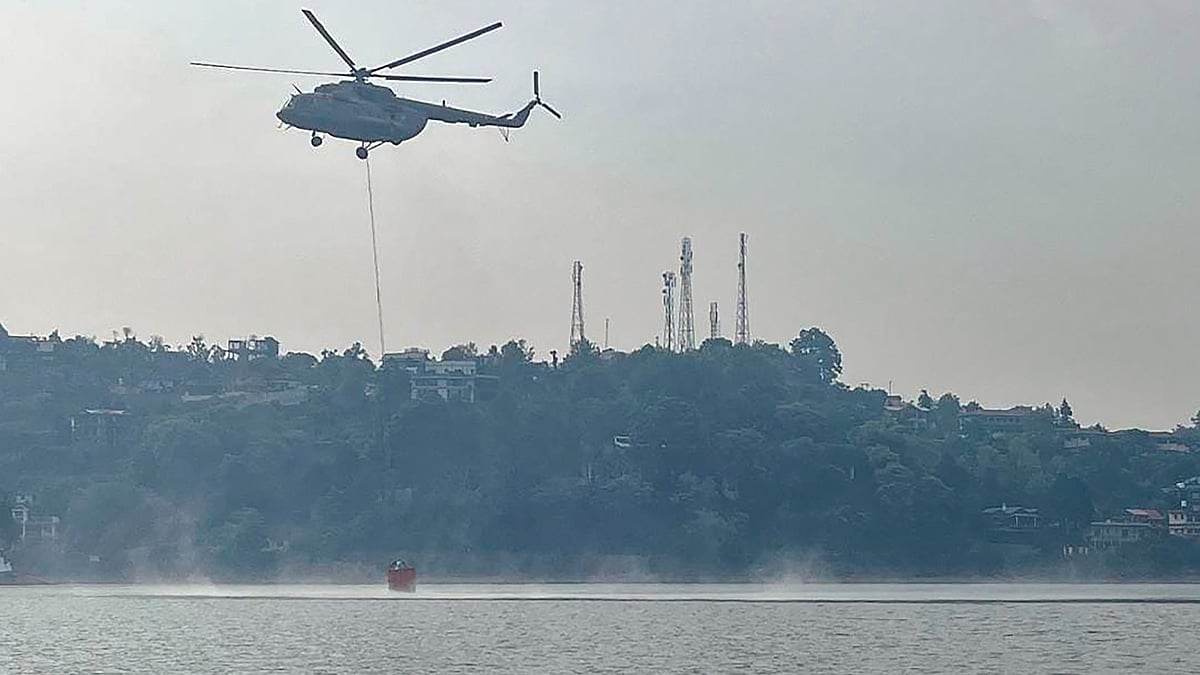 A Mi-17 V5 helicopter conducts 'Bambi Bucket Operation' to control the fire in Nainital on 27 April (photo: PTI)