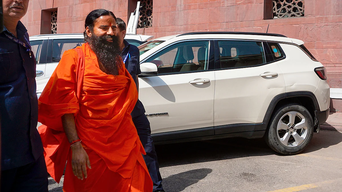 Ramdev arrives at the Supreme Court for hearing on the Patanjali misleading advertisements case, in New Delhi, 23 April (photo: PTI)