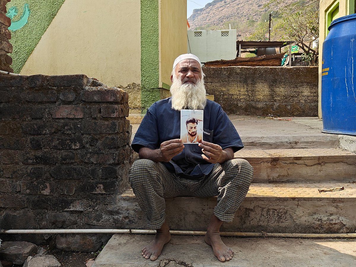 Naseem in Vardhangad holds up a photograph showing the injuries on his son, who was assaulted by a mob in June 2023 (photo: Parth M.N./PARI)
