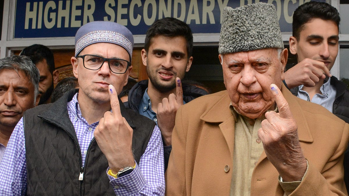 Farooq Abdullah (right) of the National Conference, son Omar Abdullah (left) and grandsons (behind) vote in Srinagar (photo: PTI) 