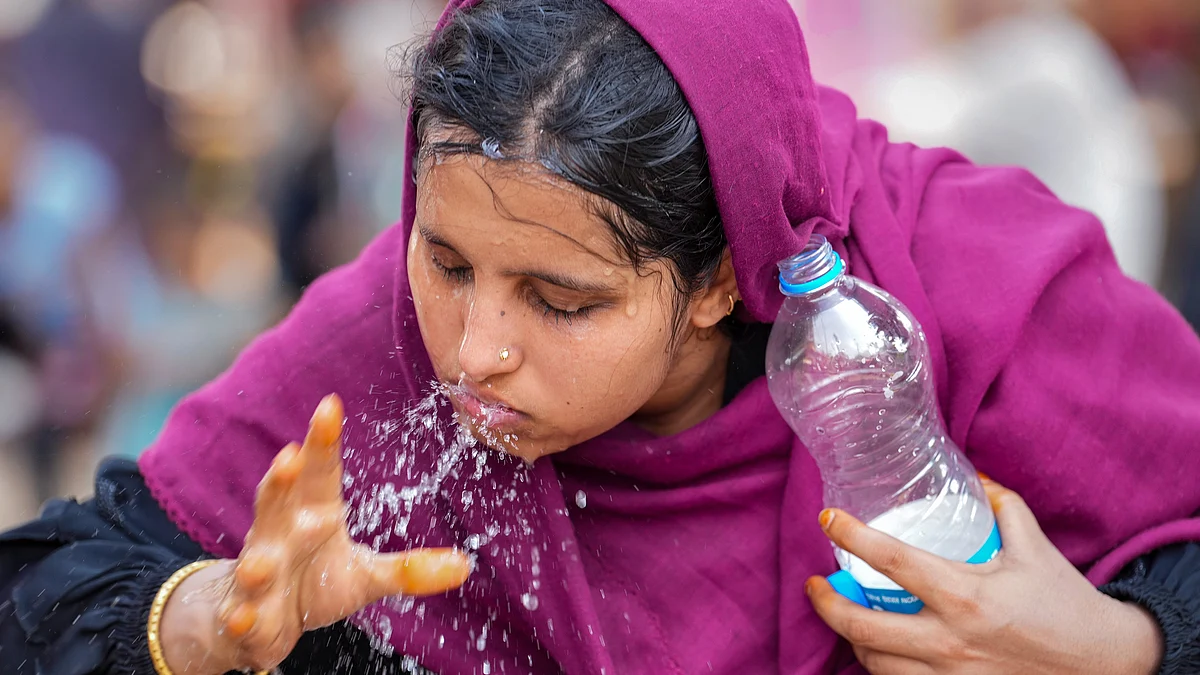 A woman splashes water on her face to get respite from heat in Ahmedabad on 13 May (photo: PTI)