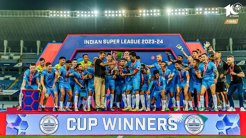 Kalyan Chaubey hands over the winners' trophy to a jubilant Mumbai City FC team on 4 May (photo: ISL)
