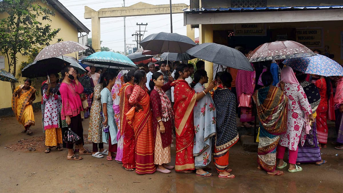 Early voters in Guwahati defy the drizzle at the polling booth (photo: PTI)