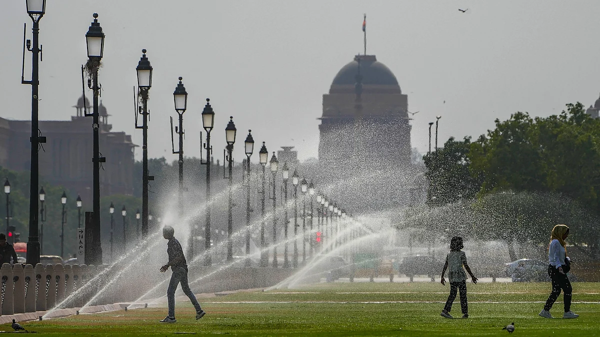 Children take advantage of lawn sprinklers in Central Delhi, near Parliament (photo: PTI)