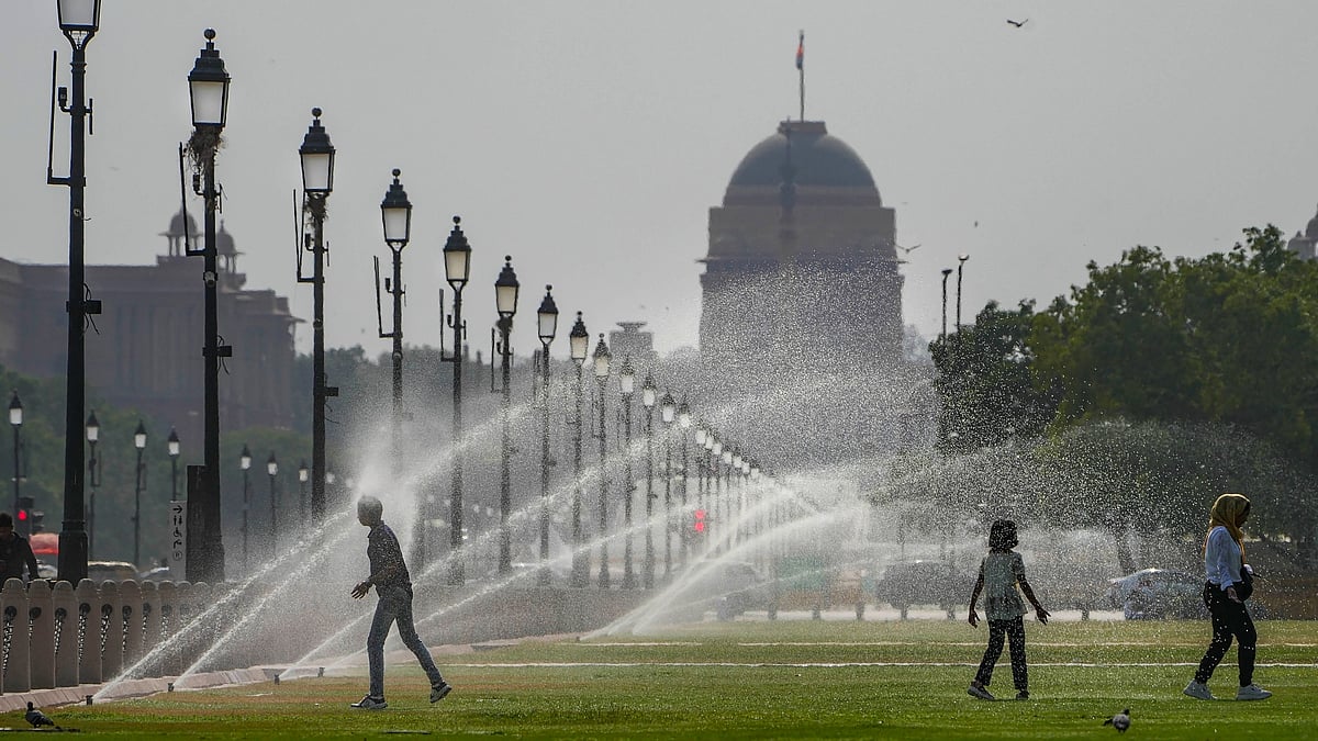 Children take advantage of lawn sprinklers in Central Delhi, near Parliament (photo: PTI)