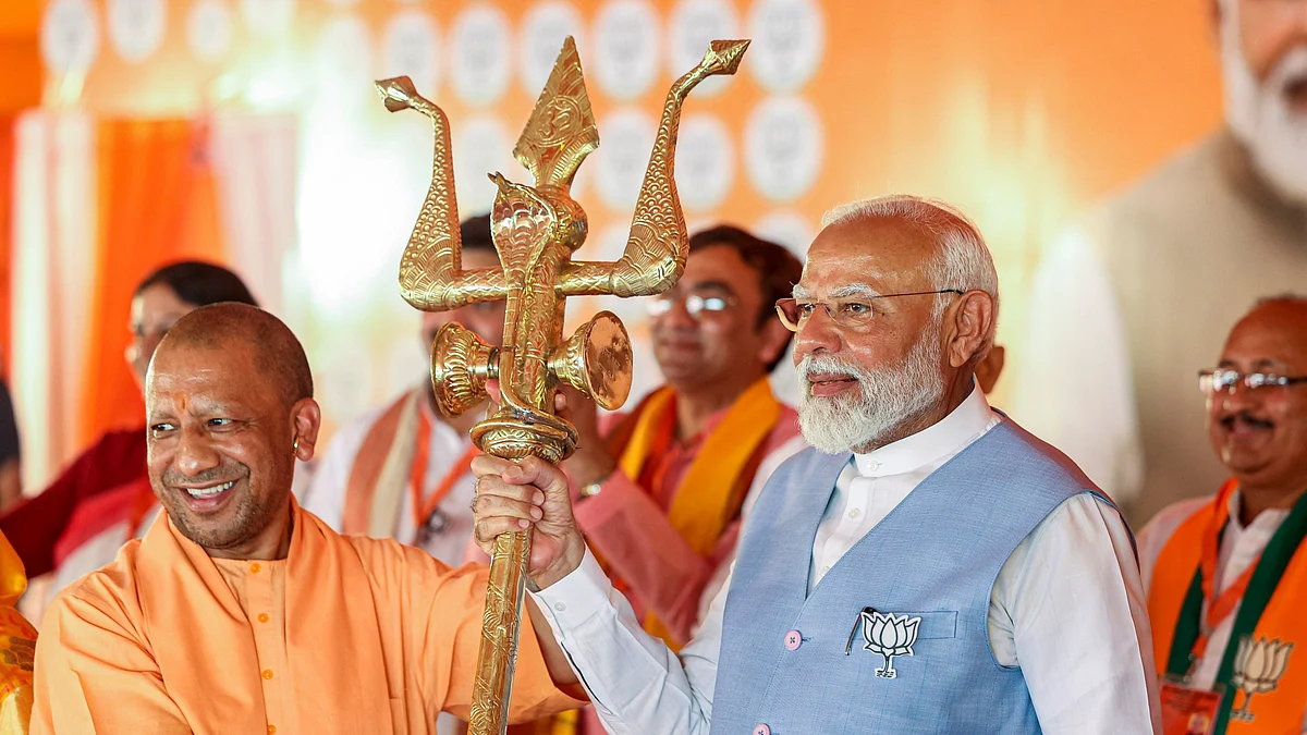 Prime Minister Narendra Modi (right) campaigns with a trishul in hand alongside Uttar Pradesh chief minister Yogi Adityanath (left) (photo: PTI)