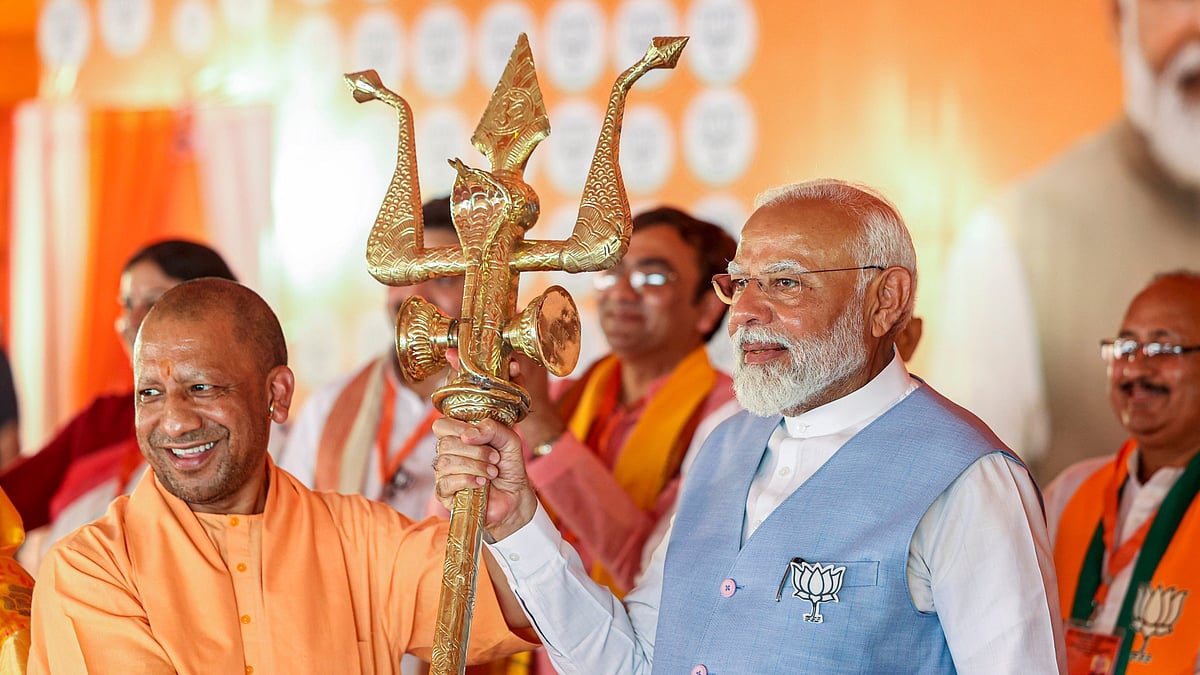 Prime Minister Narendra Modi (right) campaigns with a trishul in hand alongside Uttar Pradesh chief minister Yogi Adityanath (left) (photo: PTI)