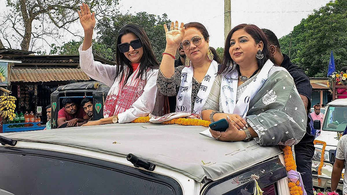 Actor Mandakini and others wave at supporters during an election roadshow in Kamrup district on 5 May (photo: PTI)