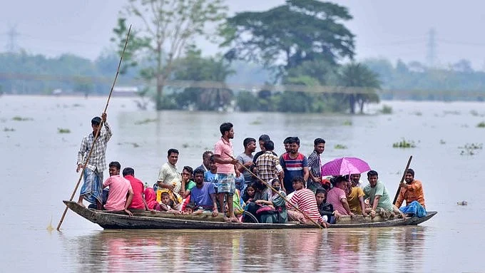 A team of boatmen try to ferry as many as they can to safety in the Assam floods (photo: @abuasimazmi/X)