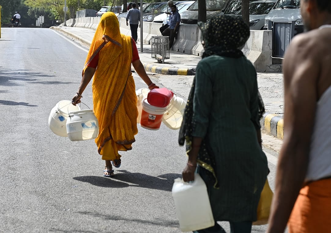 A resident rushes to collect water from a tanker in Delhi (photo: Vipin/NH)