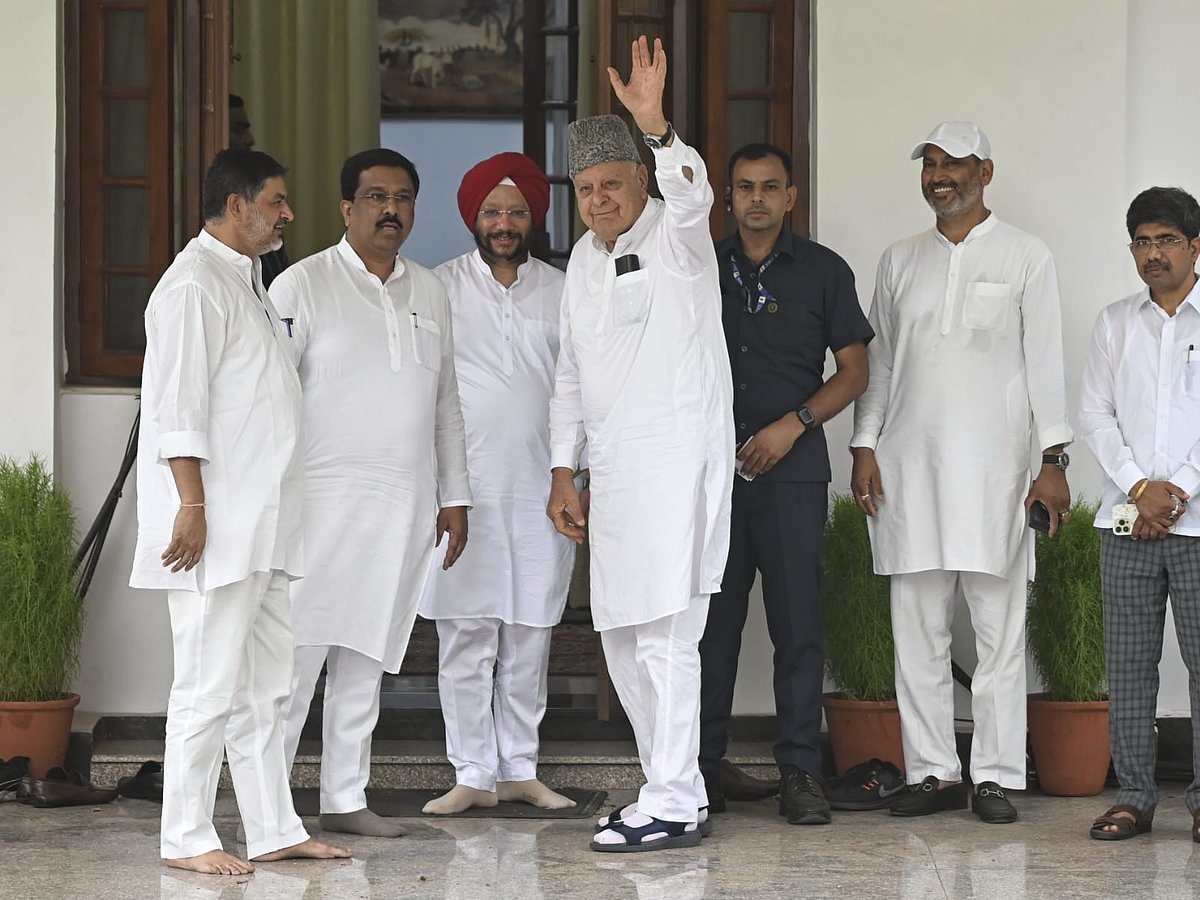 Farooq Abdullah of the National Conference lifts a hand in greeting