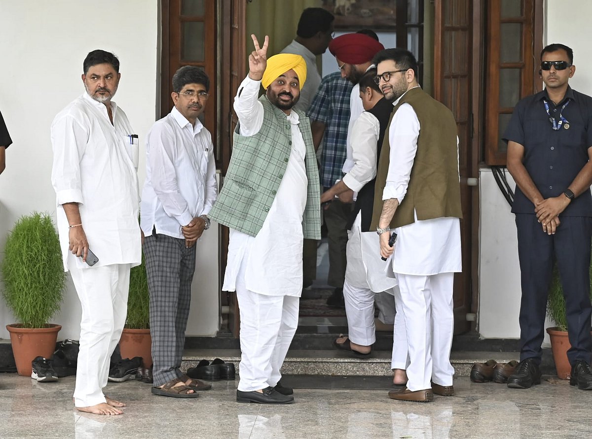 Punjab chief minister and AAP leader Bhagwant Mann (yellow turban) makes a victory sign