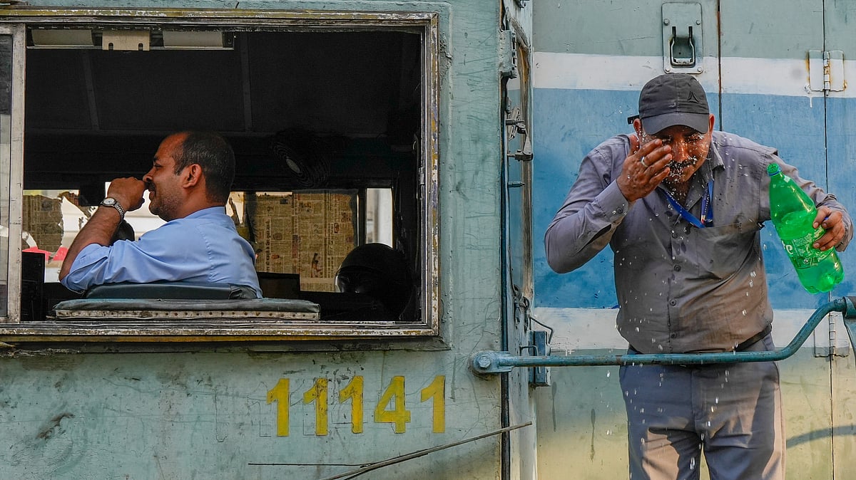 A railway staffer splashes water on his face in Lucknow on 2 June (photo: PTI)