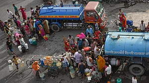 People in Delhi queue up to collect drinking water from a Delhi Jal Board tanker