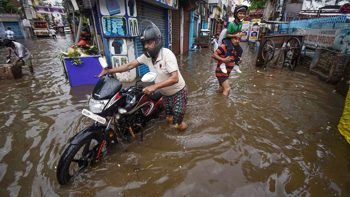 People wade through a waterlogged street in Patna on 29 June (photo: PTI)