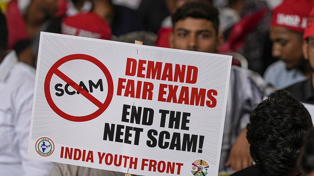 An agitator holds a placard during a protest over the alleged irregularities in NEET 2024 results