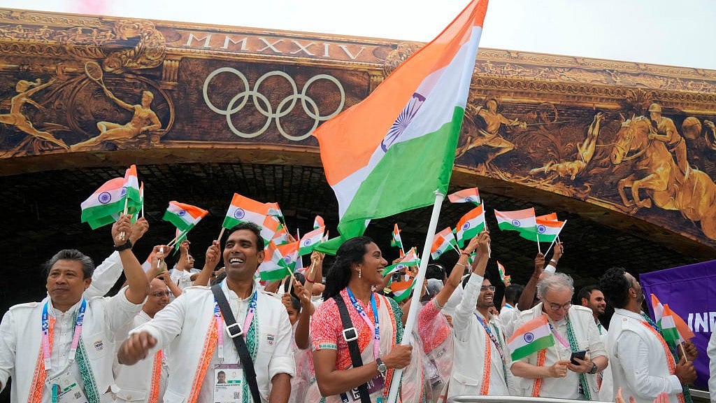 Indian athletes wave their national flags from a boat on the Seine River (photo: @Olympics/X)