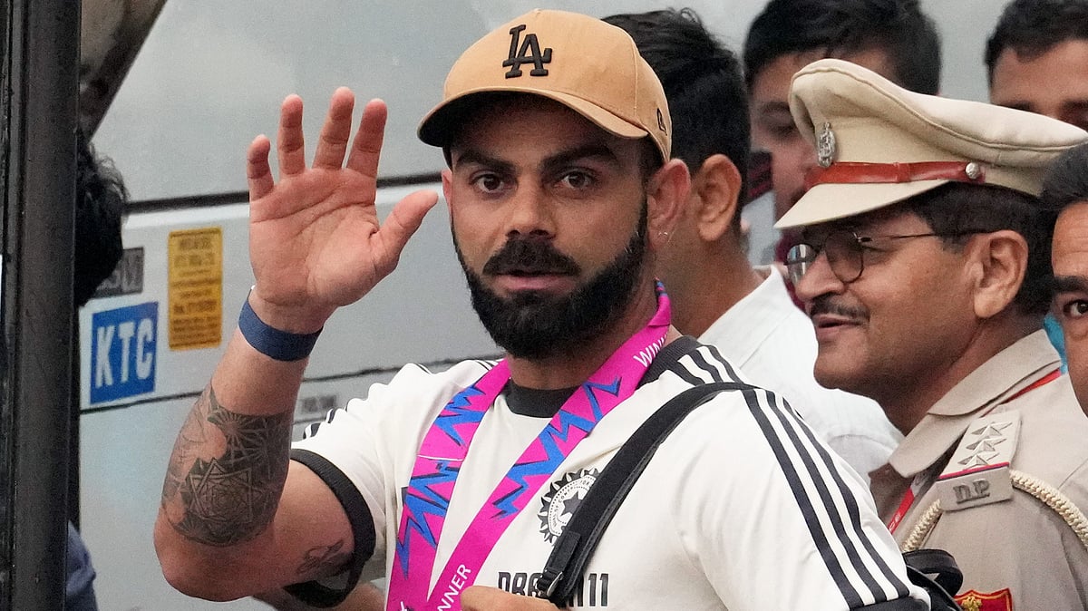 Cricketer Virat Kohli waves upon his arrival at New Delhi airport on 4 July (photo: NH)