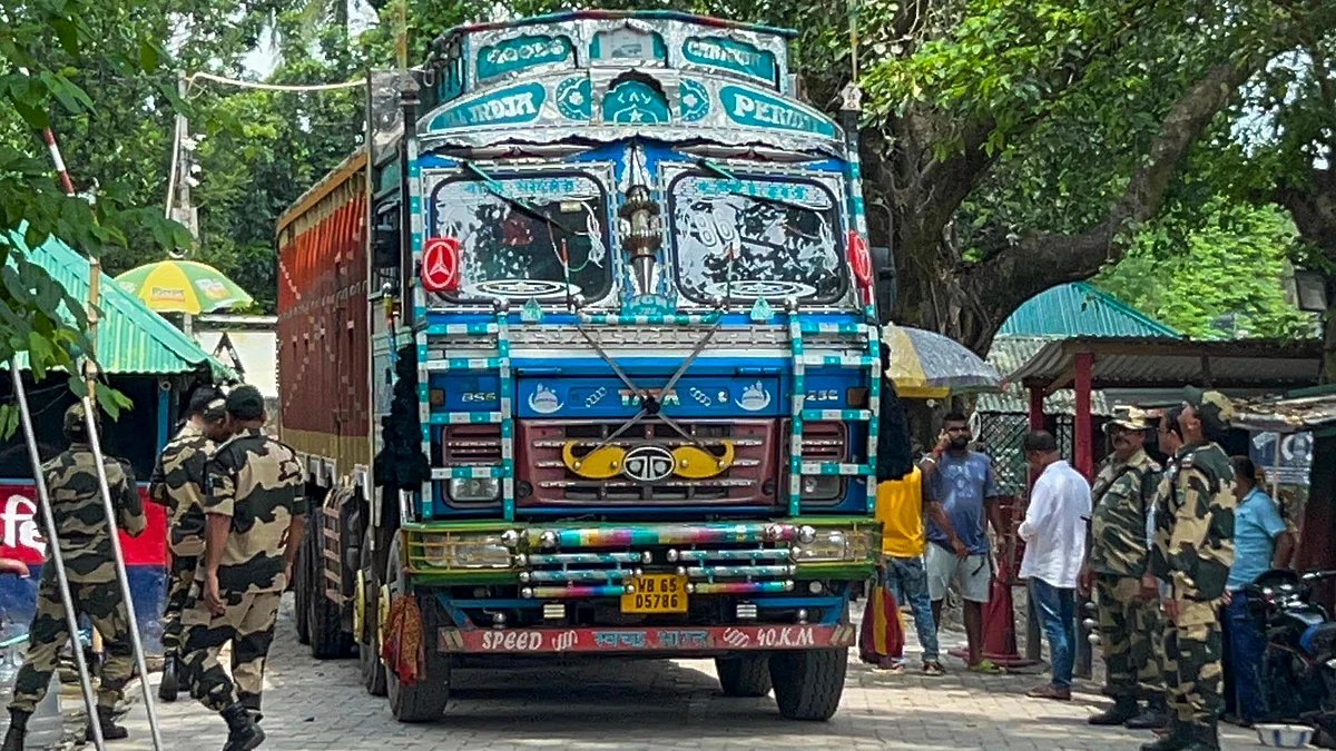 BSF personnel stand guard as a truck returns to India from Bangladesh after delivering supplies
