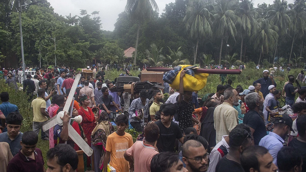 Bangladeshi people carry items from prime minister's house after they stormed into the premises, in Dhaka