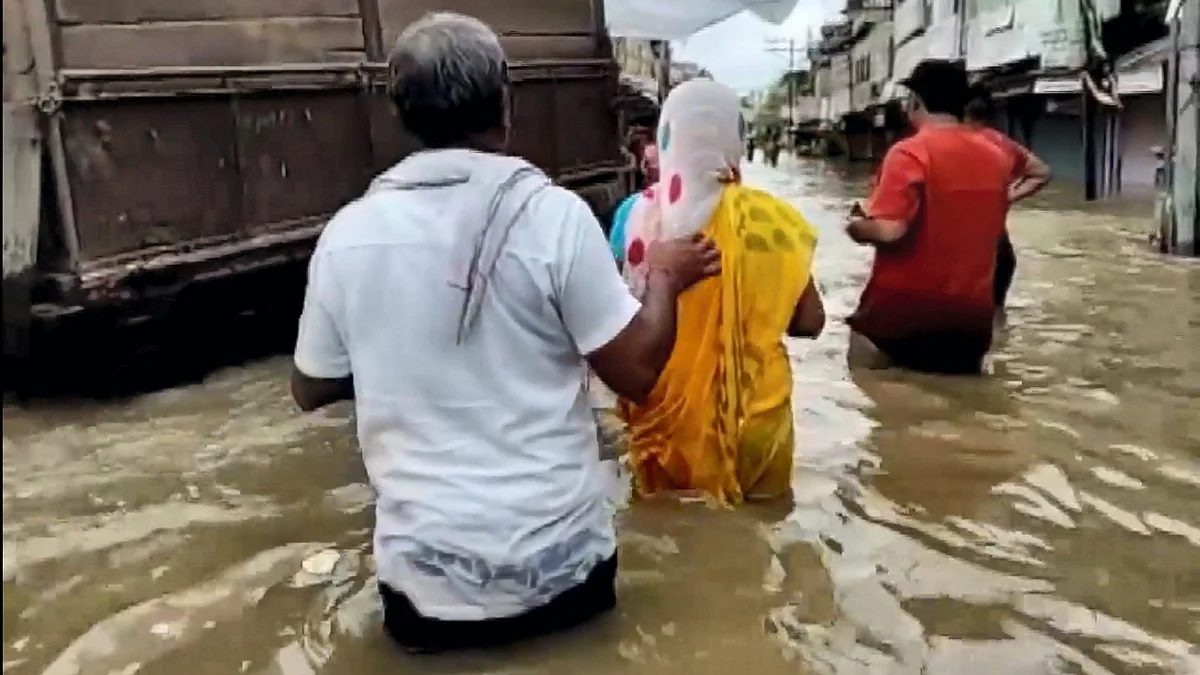 People wade through a waterlogged street in Rajasthan on 11 August (photo: PTI)
