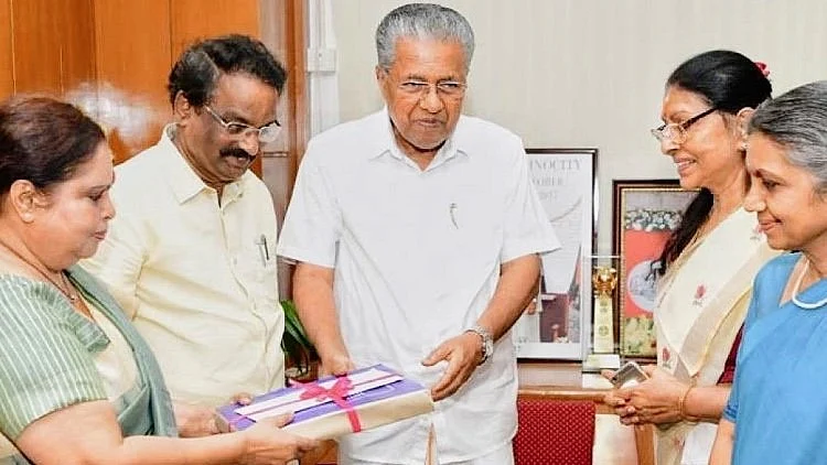 Kerala CM Pinarayi Vijayan receiving the original report (photo courtesy: @LiveLawIndia/X)