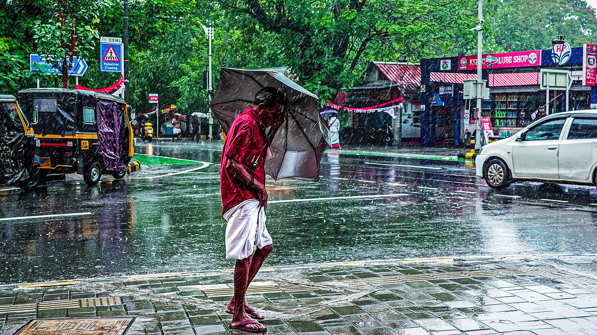 A man walks through heavy rainfall in Kochi