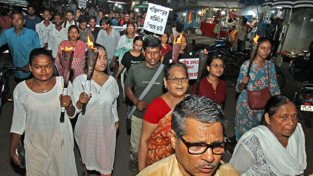 People carry torches during a protest march against the rape and murder of a trainee doctor, 4 Sept