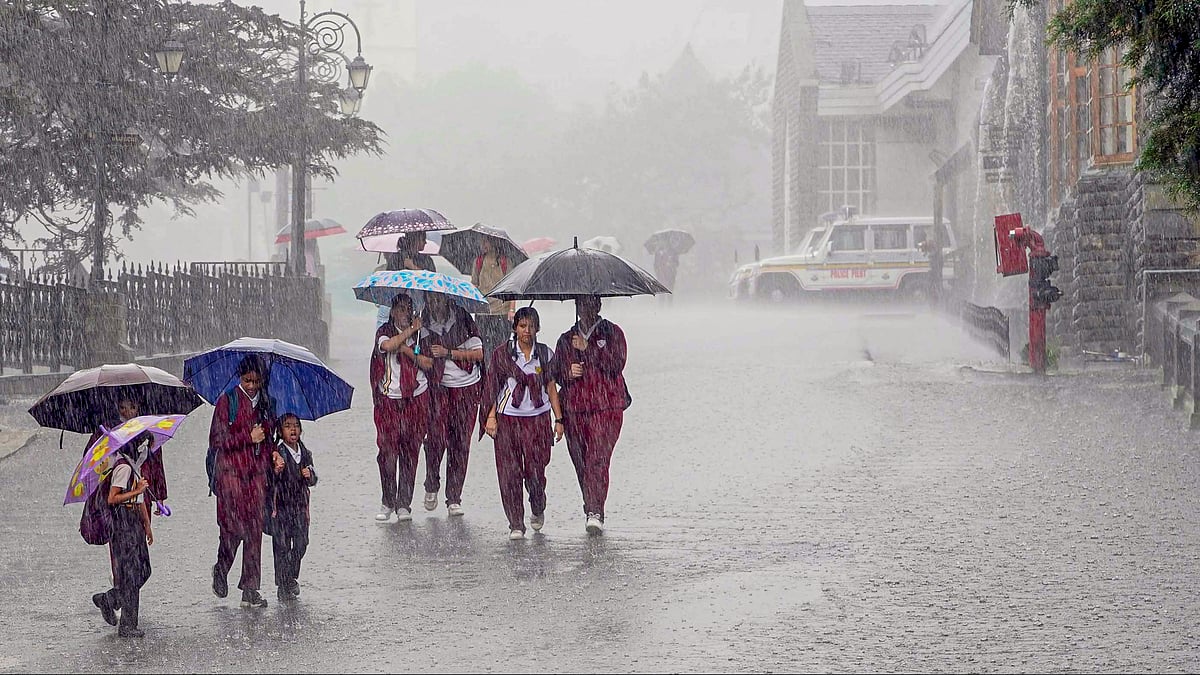 Students protest themselves from rain in Shimla on 7 September (photo: PTI)