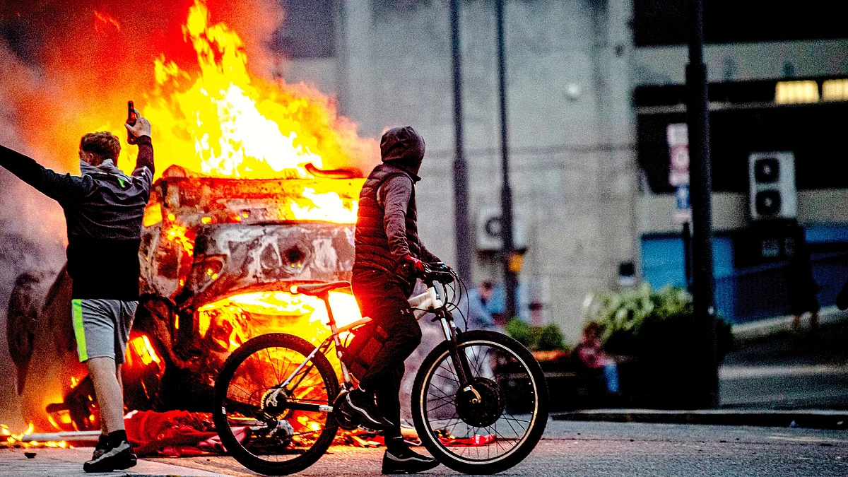 Race rioters set a police car on fire in Sunderland, England