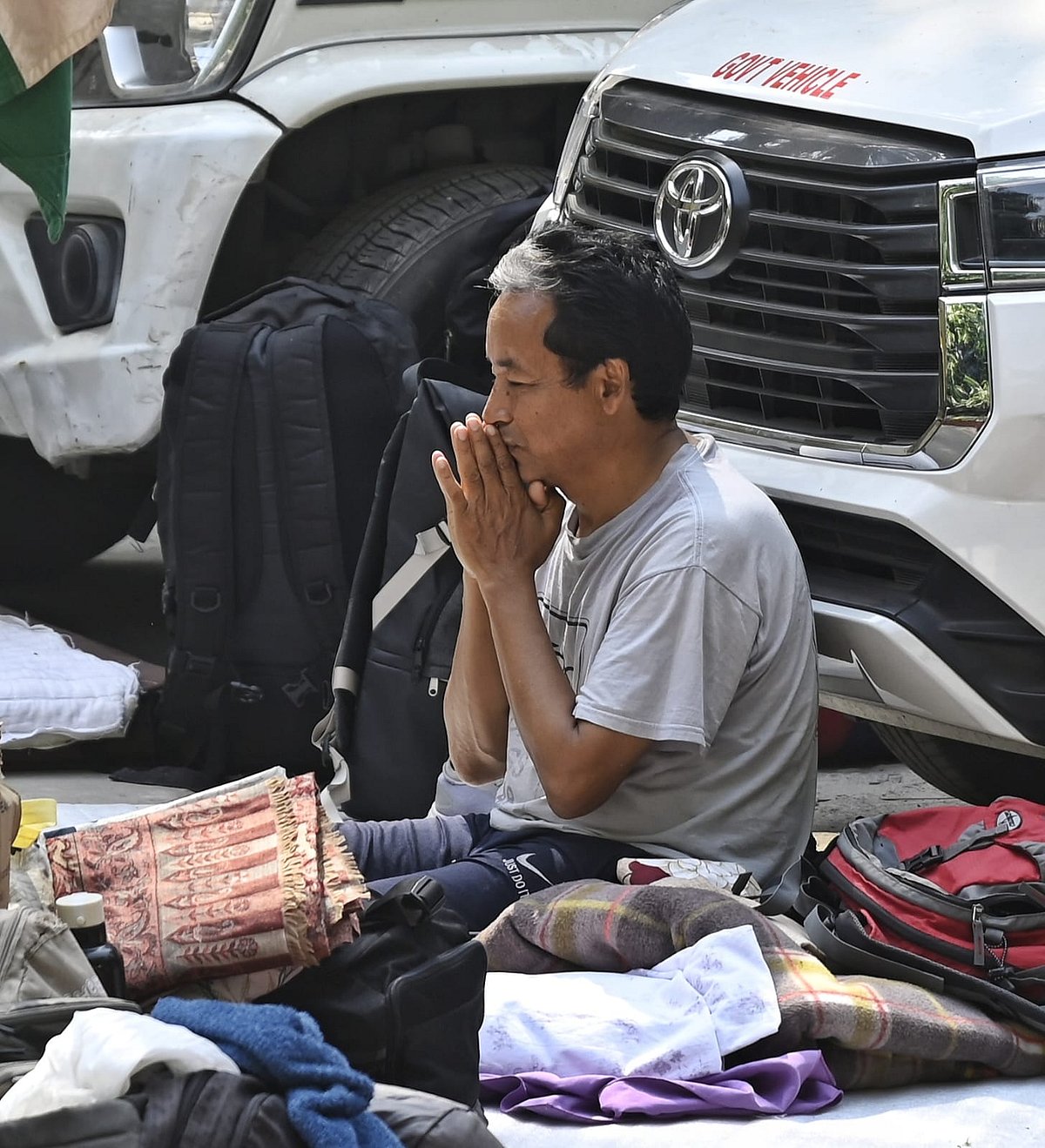 Sonam Wangchuk sits up in his bed roll outside Ladakh Bhawan, where he and others are on hunger strike (photo: Vipin)