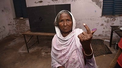 In Jaipur, a senior citizen shows off her inked index finger after voting