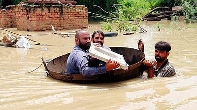 Residents in a makeshift boat amid floods caused by heavy rains in Pakistan