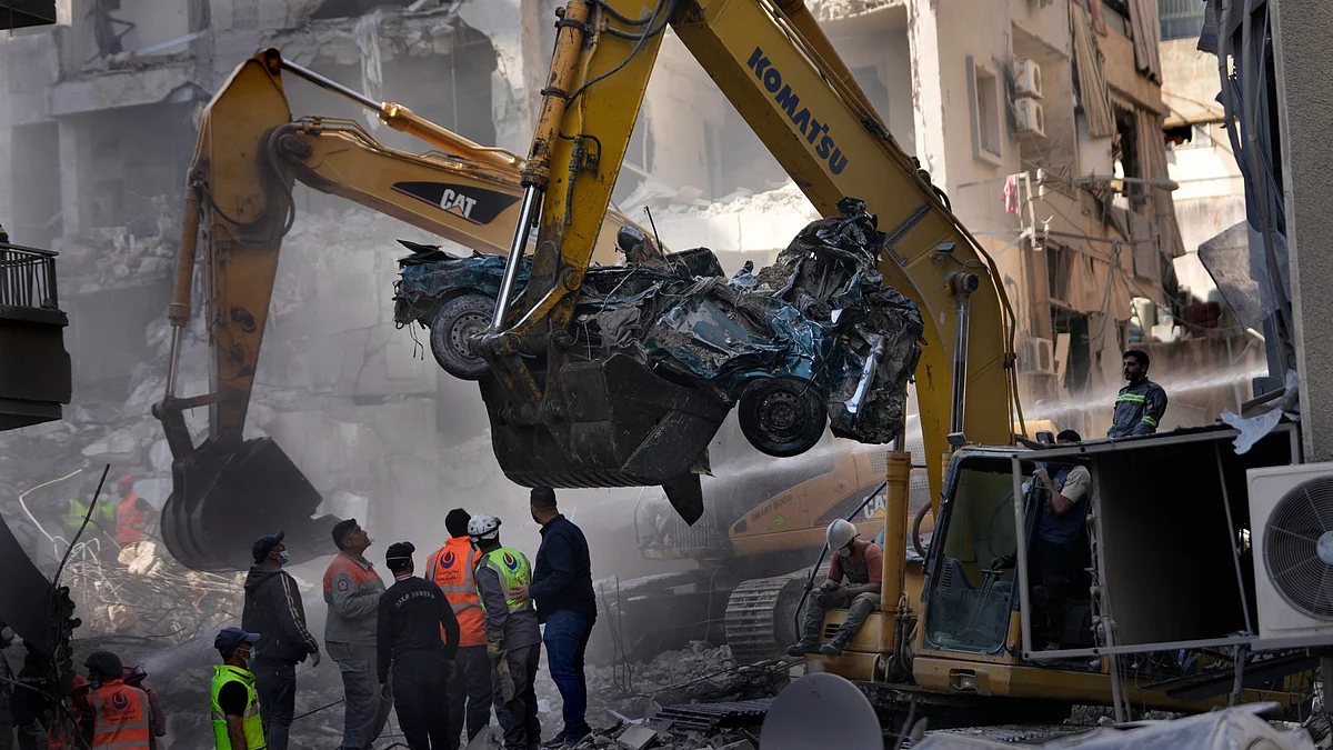An excavator removes a destroyed car in Lebanon on 23 November (photo: PTI)