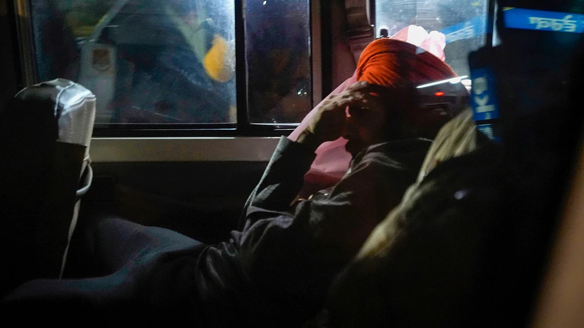 A Sikh deportee being escorted away from Amritsar airport in a police vehicle