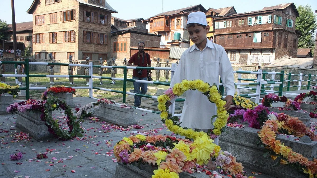 A child lays flowers on the tombs of the martyrs in Naqashbandh Sahib, Srinagar, on 13 July 2011