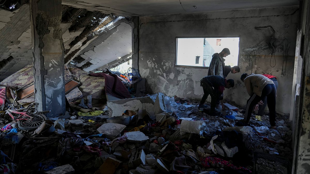 Palestinians inspect a damaged building in central Gaza Strip on 18 March (photo: AP/PTI)