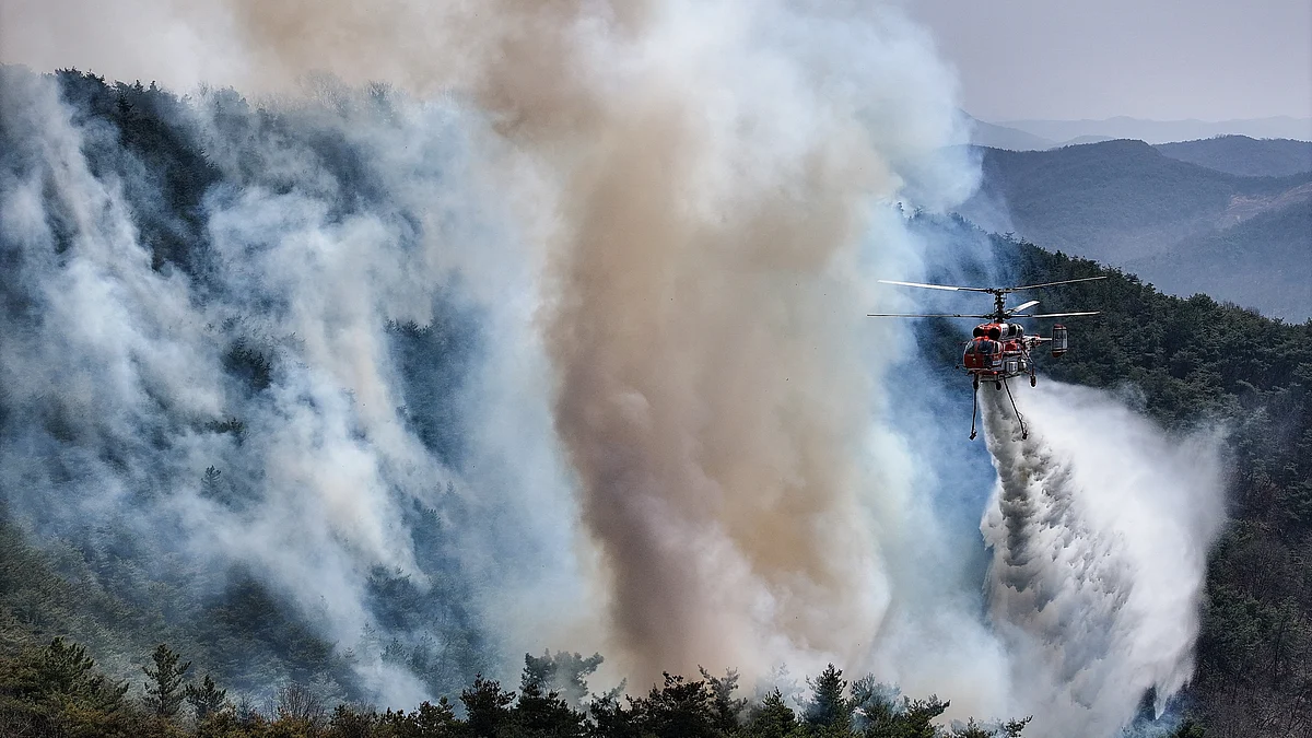 A helicopter attempts to put out the wildfire in the southeastern county of Uiseong on 23 March, 2025