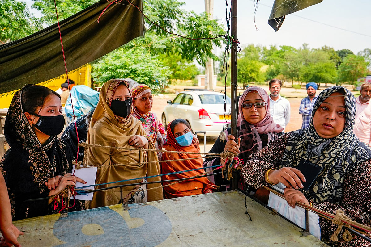 Stranded people, some holding Indian passports while their children hold Pakistani passports, wait at Attari-Wagah (photo: PTI)