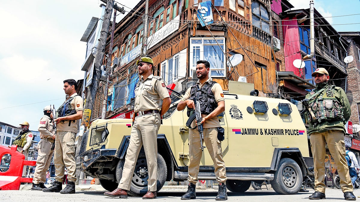 Policemen stand guard in a market in Srinagar