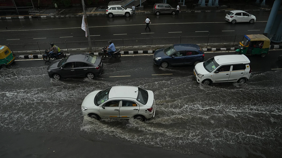 Vehicles move through a waterlogged road in New Delhi on 25 May (photo: PTI)