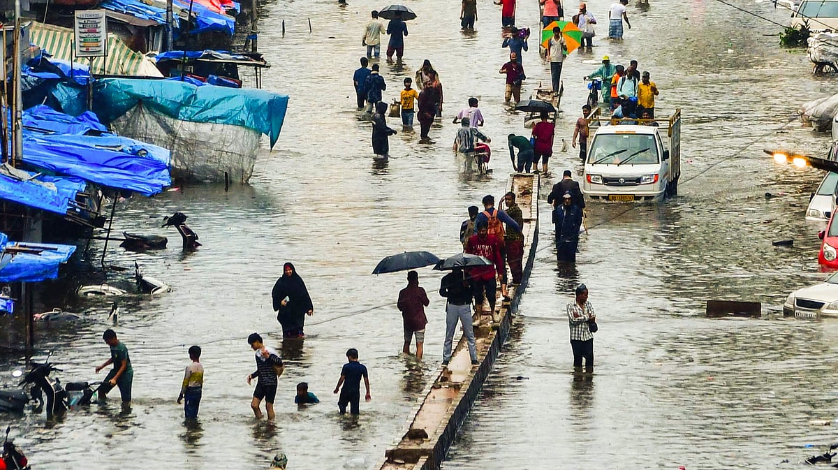People wade through water amid rains at Byculla, Mumbai