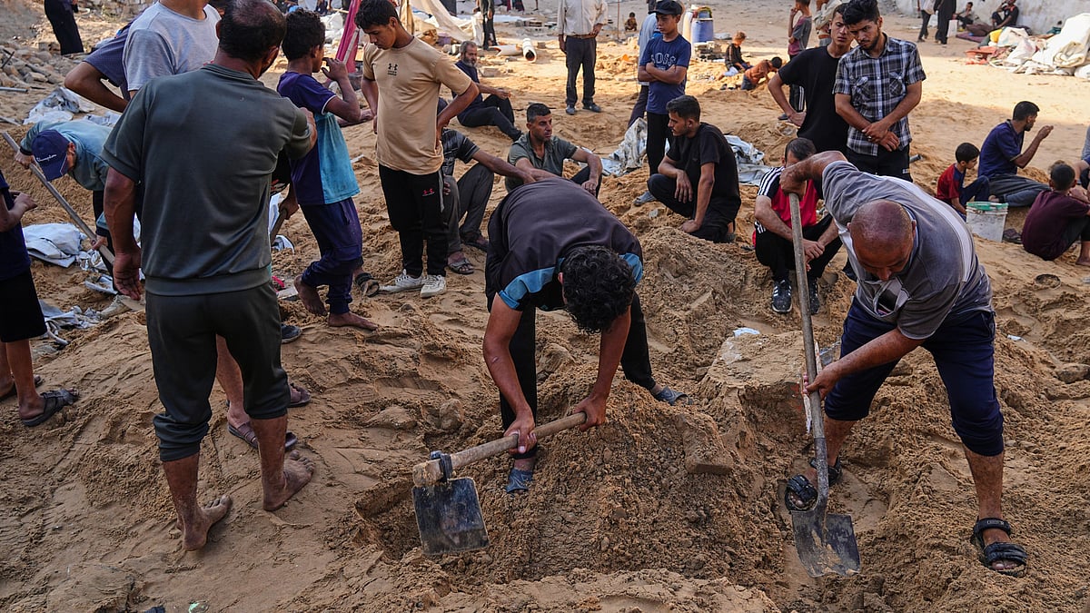 Palestinians dig through sand looking for belongings in Gaza City on 28 June (photo: AP/PTI)