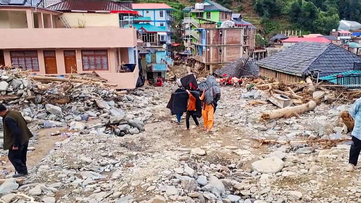 Locals walk through debris at Thunag in Mandi district, 7 July (photo: PTI)