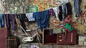 A migrant worker's little girl in Mumbai, with clothesline, cabinet... and her bicycle. Can she travel?