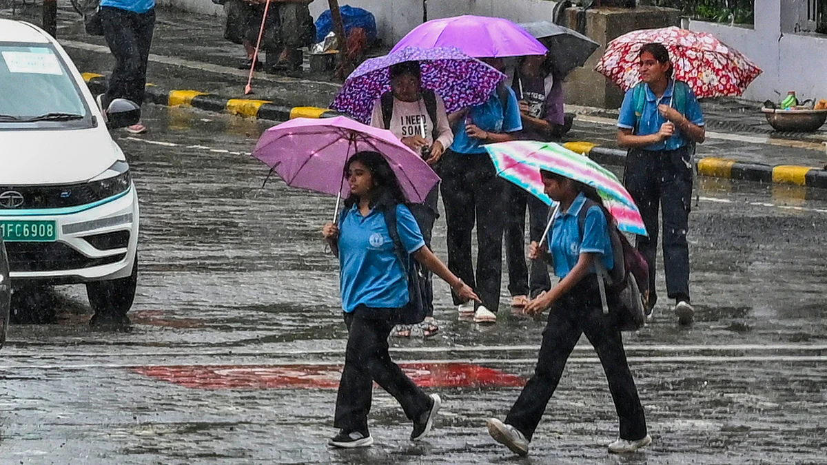 Pedestrians cross a road during rain in Nagpur on 8 July (photo: PTI)