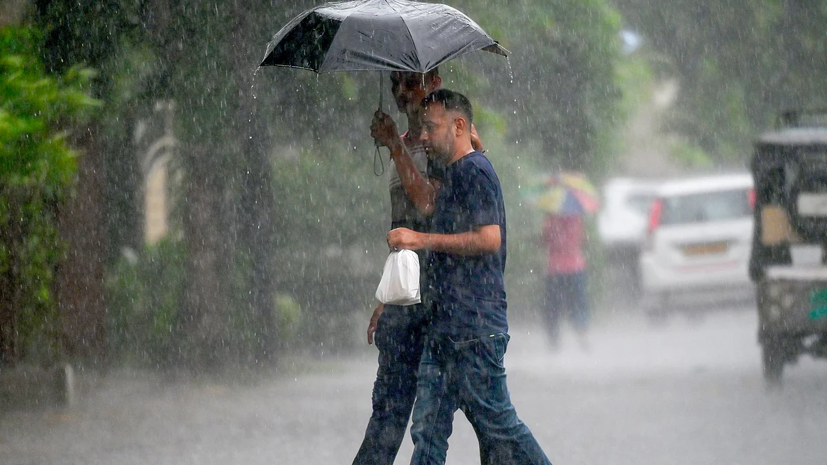 People try to protect themselves from rain in Noida on 13 July (photo: IANS)