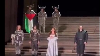 A performer holds the Palestinian flag at Opera House in London, 19 July 2025